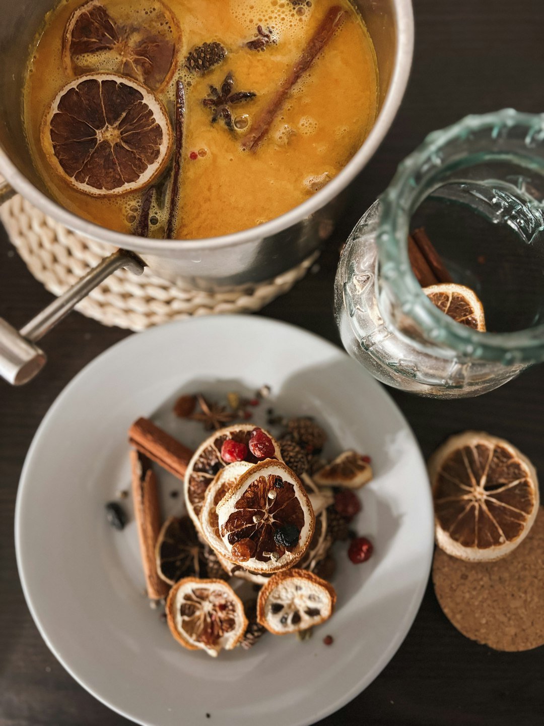 A warm citrus and spice infusion with orange slices, steeping in a glass