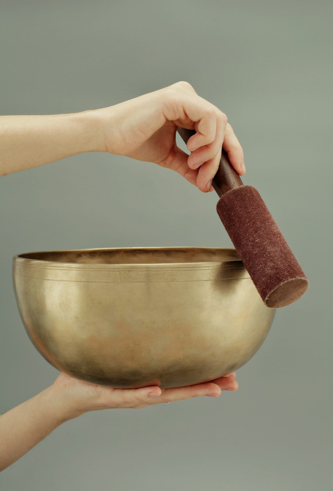 Hands holding a large singing bowl, used for sound-based space clearing